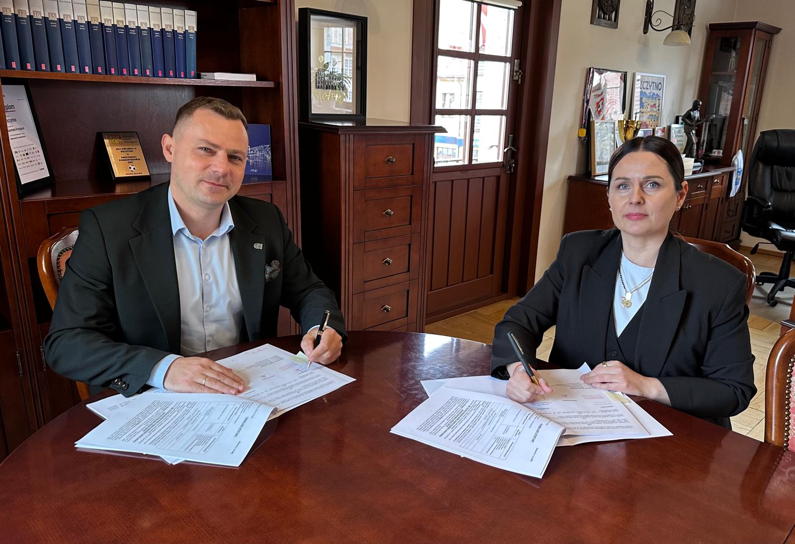 kobieta mężczyzna przy stole podpisywanie umowy 