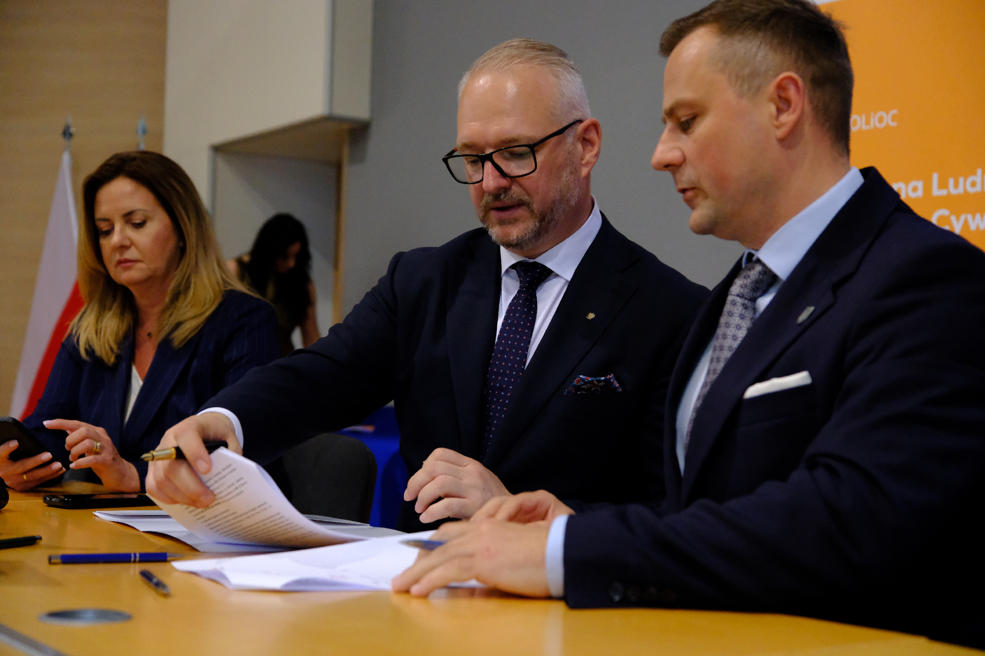 3 osoby podpisujące dokument 